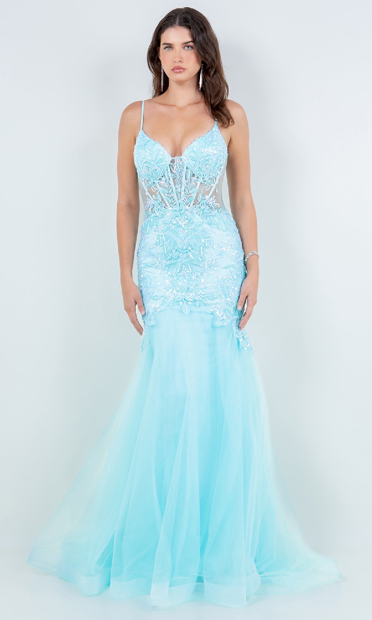 A woman wearing the Long Mermaid Prom Dress: Cinderella Couture 8276J, featuring light blue fabric, sheer panels, lace details, and thin straps stands against a plain white background.